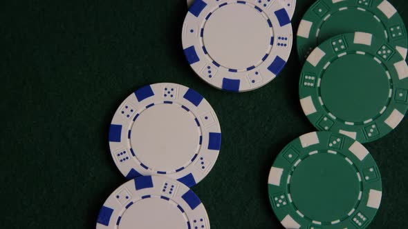 Rotating shot of poker cards and poker chips on a green felt surface - POKER 045