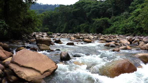 Flying very low over a mountain river full of large boulders