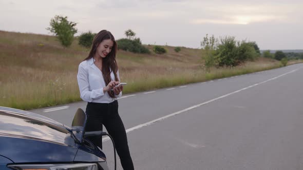 Girl Waits When Her Car Will Charge on the Road