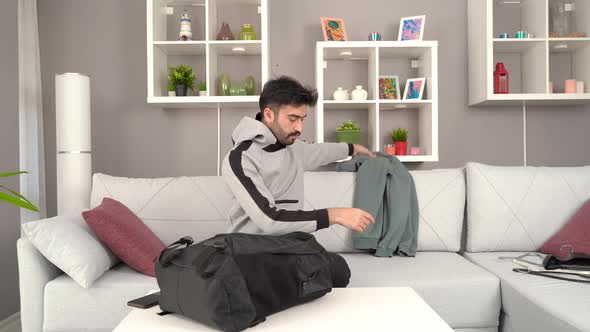 Man takes his clothes out of his bag.