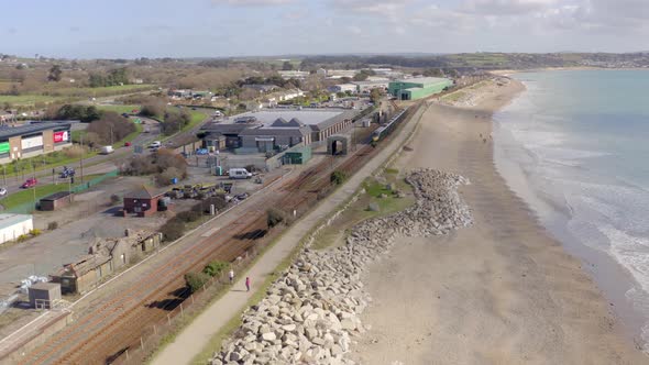 Commuter Train Accelerating Alongside the Sea