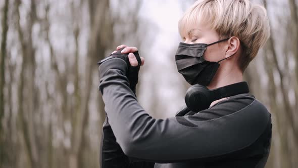 A Middle-aged Woman in a Mask Is Doing Morning Exercise Outside