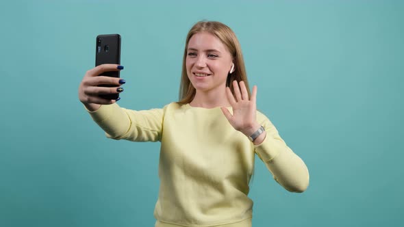 Young Girl with Blond Hair Greets Friends During Online Conversation