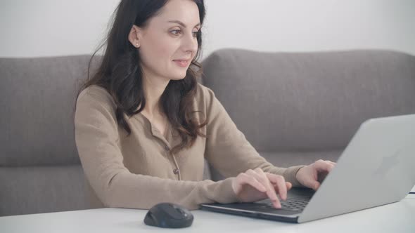 Freelancer woman in 30s working from home with modern notebook computer