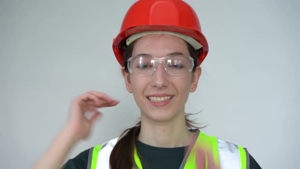 A Young Beautiful Happy Female Construction Worker Gives a Thumbs Up