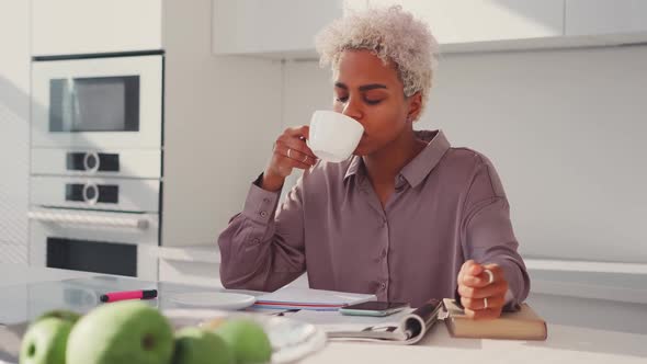 Portrait of Satisfied Young African American Woman Drinking Tea on Kitchen