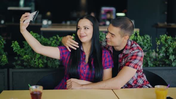 couple in love are making photo in the restaurant on the background of drinks. Selfie