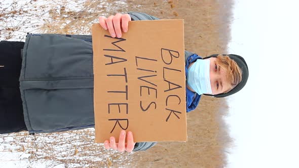 A Caucasian Man Holding a Sign with the Words BLACK LIVES MATTER