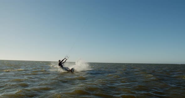 A man is gliding on water of Atlantic ocean, kitesurfing, jumping, extreme, 4k