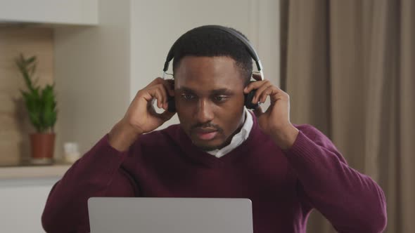 Young Adult African American Man Picks Up Headphones with Music and Starts a Dance in Front of His