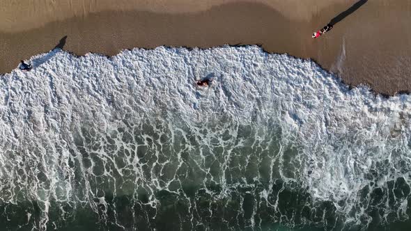 A young girl happily fights with the waves aerial view 4 K