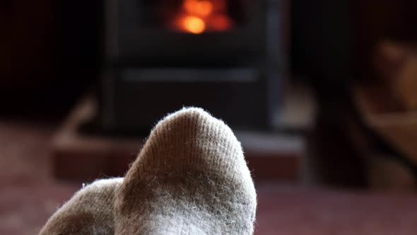 Two Pair Feet Legs in Winter Wool Socks at Fireplace Background
