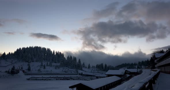 A Mountain Village Covered In Winter Snow With Cloudy Sky At Sunset - Time Lapse