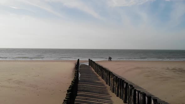 Couple walking on the beach in autumn or winter. Horizon and sea