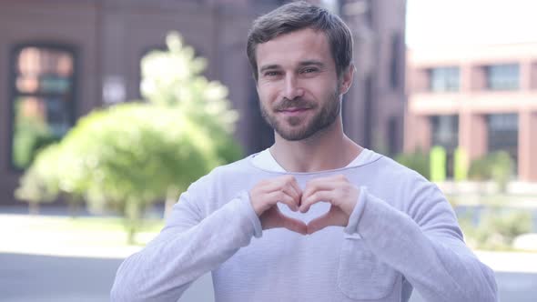 Handsome Man Gesturing Heart with Hand