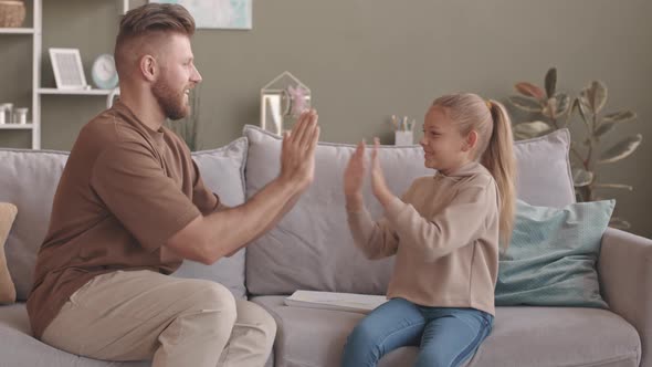 Father and Little Daughter Playing Clapping Game at Home