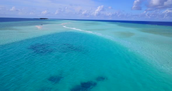 Natural fly over island view of a white paradise beach and aqua blue water background in 4K