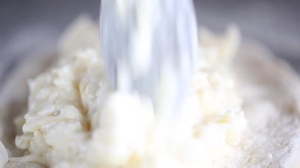 Baker prepares a pie with a cottage cheese. He puts fillings on a dough 