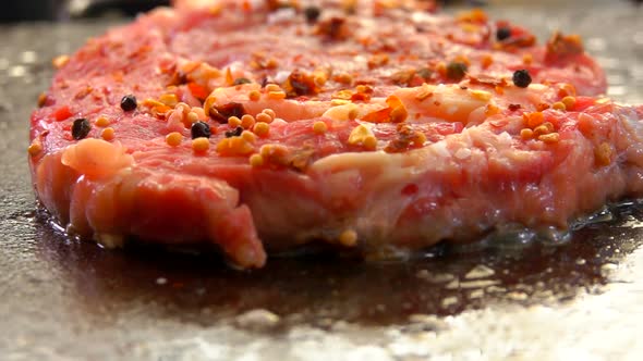 Closeup of a Steak Hissing and Frying on a Grill