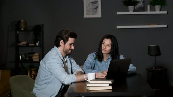 A young man and A female Colleague Discuss an Online Project, Two Managers Work at Home