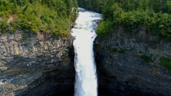 Beautiful water fall through forest cliff on a sunny day 4k