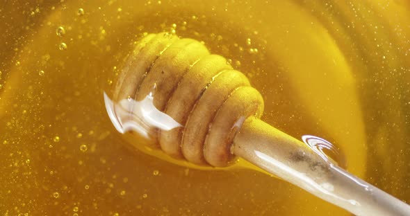 The Wooden Spoon Rotates in Fresh Honey. 