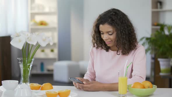 Multiracial Girl Typing Message on Mobile Phone, Healthy Lunch Break, Juicing