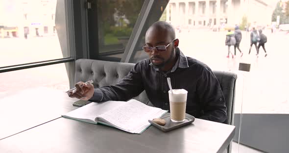 Young Black Businessman Drinking Latte on the Terrace