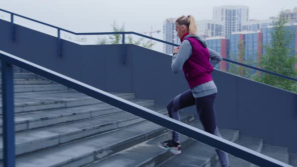 Beautiful Blonde Runs Up Steps in Urban Street