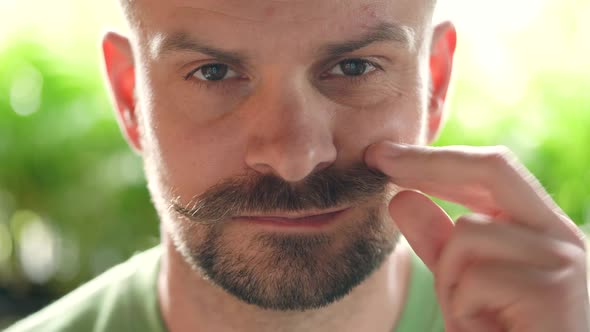 Handsome Man with Twisted Mustache Looking at the Camera