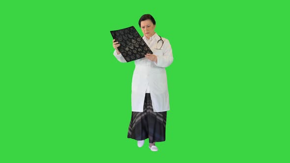 Mature Female Specialist Checking Brain Tomography Results While Walking on a Green Screen Chroma