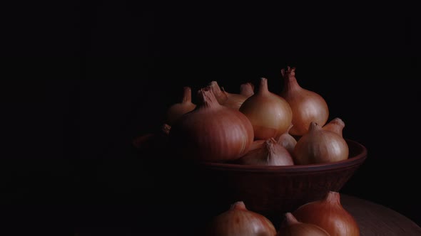 Pile of Whole Bulbs of Raw Onion in Ceramic Bowl on Table