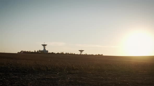 Wide Aerial Drone Shot of Two Telecommunications Antenna or Radio Telescope Satellite Dish on Sunset