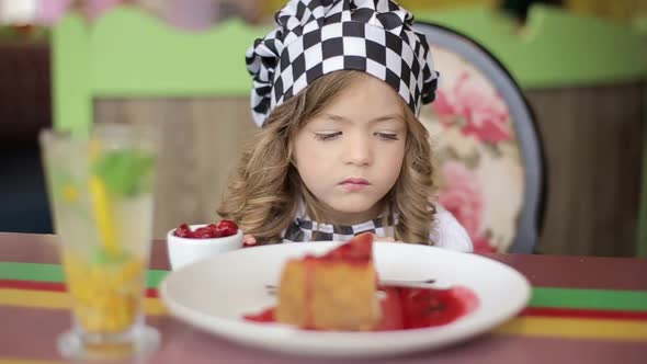 A charming little girl who eats a fresh sweet chocolate pie.