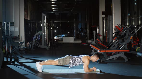 Sportsman Doing Plank Pose Cardio Workouts on Floor Fitness Mat in Gym