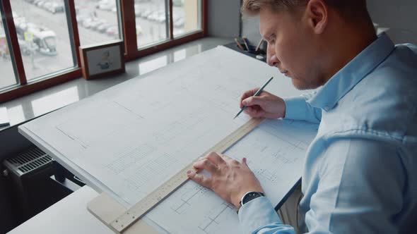 Working engineer drawing construction plan in office