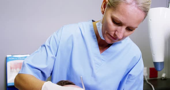 Dentist examining a male patient with dental tools