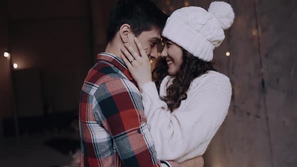 Close Up of Young Beautiful Blonde Woman Hugging Man Holding Christmas Present. Family Tradition