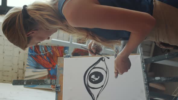 Talented Female Artist Painting Eye with Black Paint