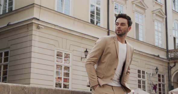 A Guy In A Light Suit Walks Around The City