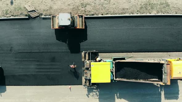 Workers Are Making an Asphalt Motorway. Asphalt Paver Machine on a Road Construction Site.