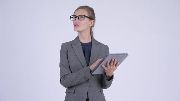 Young Happy Businesswoman Thinking While Using Digital Tablet