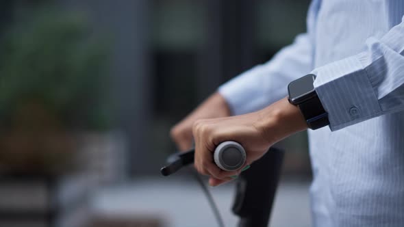 Closeup Hands on Electric Scooter Handlebar Riding Downtown