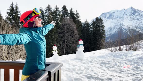 Woman Stand on the Balcony Stretching Hands Wearing Ski Helmet