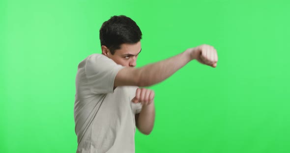 Young Sporty Guy Exercising Punches and Blocks