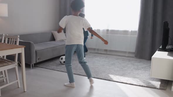 Handheld Children in Selfisolation Caucasian Boy and African Girl Playing with a Soccer Ball in the