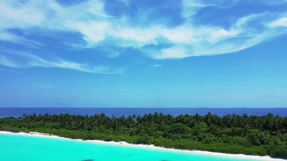 Wide above copy space shot of a paradise sunny white sand beach and blue ocean background in 4K