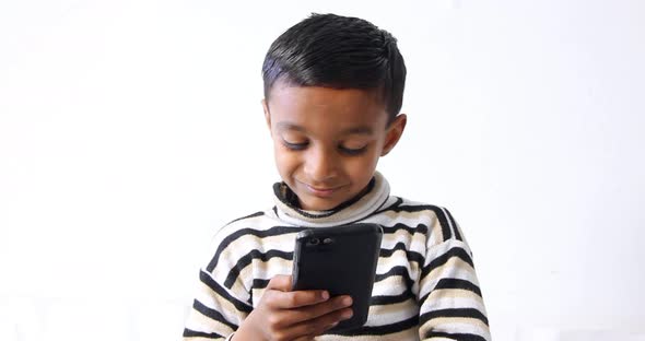kid using a mobile phone and keep it smile