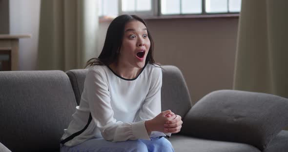 Excited Asian Girl Watching Tv at Home
