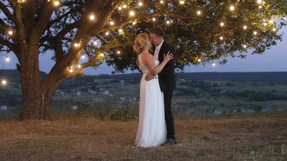 Groom tenderly embraces his bride